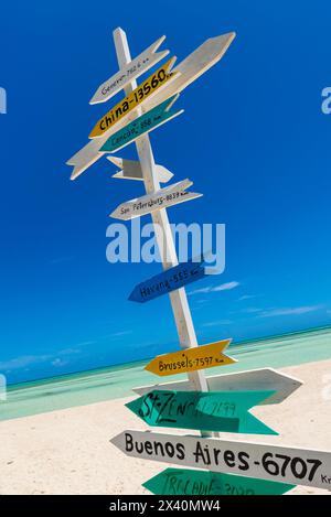 Wegweiser an einem tropischen weißen Sandstrand, der die Entfernung zu Ländern auf der ganzen Welt von Kuba in der Karibik zeigt; Cayo Guillermo, Kuba Stockfoto