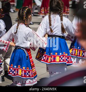 Kleine Mädchen tanzen im Sommer im Freien. Bulgarische ethnische Kunst Stockfoto