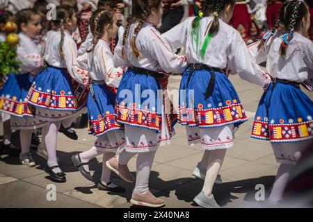 Mädchen im Schulalter in traditionellen bulgarischen Kostümen tanzen Volkstanz, Rückansicht Stockfoto