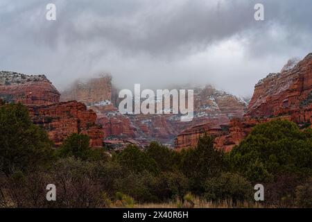 Wolken umhüllen die roten Felsformationen in Sedona, im Inneren Kaparral, Halbwüstenrasen, Great Basin Conifer Waldbiome von n... Stockfoto