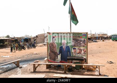 Eindrücke aus Burkina Faso Burkina Faso, am Rande von Ouagadougou, 05.03.2024: An einer Strassenkreuzung mehrere Holzbänke und ein Plakat vom Interimsstaatschef von Burkina Faso Ibrahim TraorÃ schütteit die Hand mit dem russischen Präsidenten Wladimir Putin. Auf dem Plakat ist zu lesen Soutien a la Transition Übergangsunterstützung. *** Impressionen aus Burkina Faso Burkina Faso, am Stadtrand von Ouagadougou, 05 03 2024 an einer Kreuzung mehrere Holzbänke und ein Poster des Übergangspräsidenten von Burkina Faso Ibrahim TraorÃ, der dem russischen Präsidenten Wladimir Putin der poste die Hand schüttelt Stockfoto