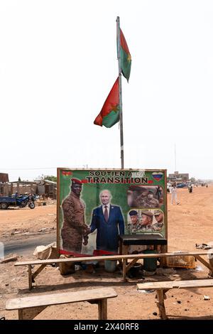 Eindrücke aus Burkina Faso Burkina Faso, am Rande von Ouagadougou, 05.03.2024: An einer Strassenkreuzung mehrere Holzbänke und ein Plakat vom Interimsstaatschef von Burkina Faso Ibrahim TraorÃ schütteit die Hand mit dem russischen Präsidenten Wladimir Putin. Auf dem Plakat ist zu lesen Soutien a la Transition Übergangsunterstützung. *** Impressionen aus Burkina Faso Burkina Faso, am Stadtrand von Ouagadougou, 05 03 2024 an einer Kreuzung mehrere Holzbänke und ein Poster des Übergangspräsidenten von Burkina Faso Ibrahim TraorÃ, der dem russischen Präsidenten Wladimir Putin der poste die Hand schüttelt Stockfoto