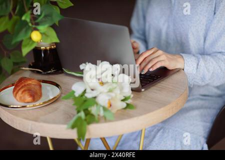 Unerkennbare Frau, die im Café einen Laptop benutzt Stockfoto