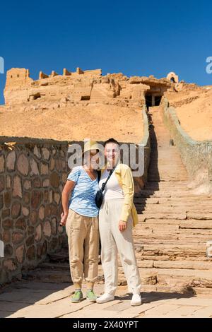 Weibliche Touristen, die zu den Gräbern der Adligen in Assuan, Ägypten, Assuan, Nubien, Ägypten aufsteigen Stockfoto
