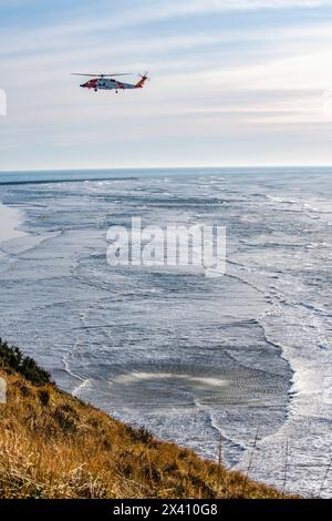 Die Crew der US-Küstenwache sitzt unter einem Sikorsky MH-60J Jayhawk, der Rettungsübungen im Cape Enttäuschung State Park in der Nähe des Mo... Stockfoto