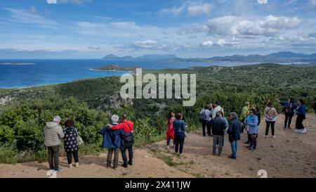Touristen blicken auf eine riesige Mittelmeerregion mit üppiger Vegetation und einer ausgedehnten Inselküste, Sardinien, Italien Stockfoto