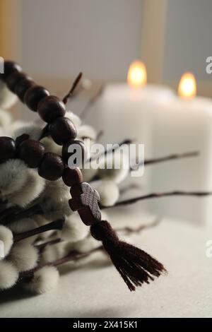 Rosenkranzperlen und Weidenzweige auf dem Tisch, Nahaufnahme Stockfoto