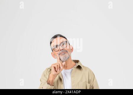 Mann mit Bart und Brille, der aufblickt Stockfoto