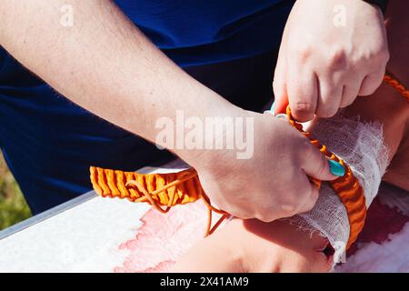 Der Sanitäter legt einen Tourniquet am Arm an. Medizinische Ausbildung. Stockfoto