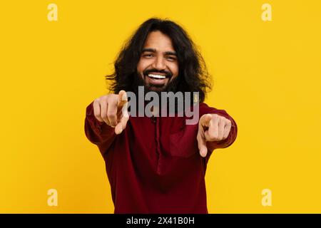 Bärtiger Mann mit langen Haaren, der auf die Kamera zeigt Stockfoto