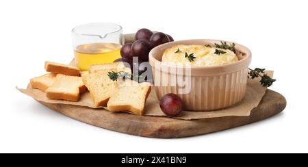 Leckerer gebackener Camembert in Schüssel, Croutons, Trauben, Honig und Thymian auf weißem Hintergrund Stockfoto