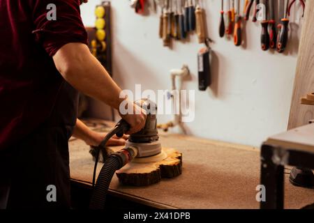 Tischler mit Schwingschleifer mit feineren Schleifpapierkörnern für ein glatteres und feineres Finish. Holzarbeiter mit Winkelschleifer auf Holz, um professionelle Ergebnisse zu erzielen Stockfoto