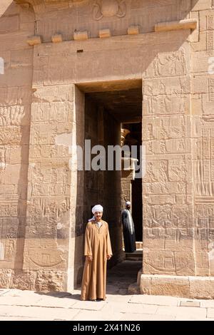 Ein ägyptischer Mann in traditioneller Kleidung im Tempel der Isis im Philae Tempelkomplex (UNESCO-Weltkulturerbe) auf der Insel Agilkia, Ägypten Stockfoto