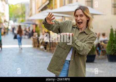 Fröhliches reiches Touristenmädchen, das verschwendet, Geld um die Hand wirft, mehr Trinkgelder, großer Gewinn, Gewinnlotterie, Anteil, feiern Sie draußen. Glückliche junge Frau, die auf der städtischen Straße steht. Stockfoto