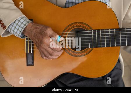 Details des Streichinstrumentes, Hände einer Person mit Musikakkorden auf der Gitarre. Lifestyle und Musikhintergrund Stockfoto