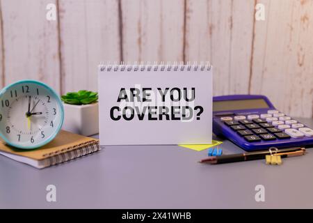 Sind Sie abgedeckt? Concept Words sind auf Holzklötzen bedeckt. Schöner rosafarbener Hintergrund mit Boot. Business und sind Sie von dem Konzept abgedeckt. Cop Stockfoto