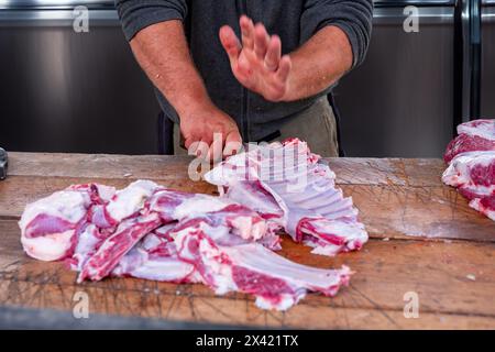 Muslimische Metzger schneiden ein Schaf, um es während des Eid Al-Adha Al Mubarak an bedürftige muslime zu verteilen Stockfoto