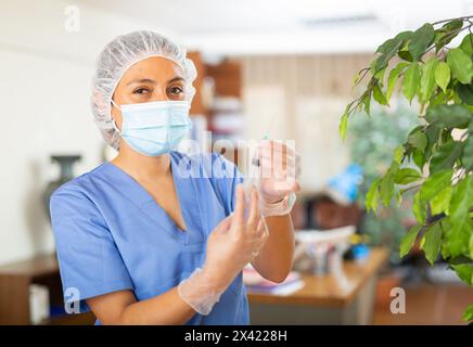 Positive Frau im Gesundheitswesen hält Spritze für die Injektion Stockfoto