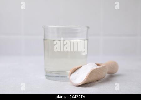 Essig in Glas, Natron und Holzlöffel auf dem Leuchttisch Stockfoto