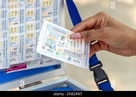 THAILAND, 13. April 2024, Kauf einer Lotterie - Thai Government Lottery, bei einem Straßenverkäufer Stockfoto