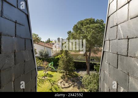 Ein Fenster mit Blick in ein Ferienhaus mit schrulligen Dächern mit schwarzen Schieferziegeln Stockfoto