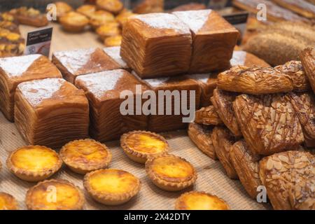 Kuala Lumpur, Malaysia - April 14,2024 : verschiedene Eierkörtchen und Gebäck werden auf Tabletts in der Bäckerei angeboten. Stockfoto