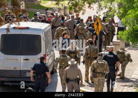 Austin, Texas, USA, 29. April 2024: Demonstranten stellen sich während einer pro-palästinensischen Kundgebung an der University of Texas in Austin gegen Polizeibeamte und einen Polizeiwagen. Der Campus wurde an einem dritten Tag in Folge von Demonstrationen erschüttert, als Dutzende Studenten und Unterstützer versuchten, eine Zeltstadt in der Nähe des Hauptverwaltungsgebäudes zu errichten. Texas State Troopers, Austin Polizei und UT Polizei verhafteten Dutzende von Menschen. Quelle: Bob Daemmrich/Alamy Live News Stockfoto