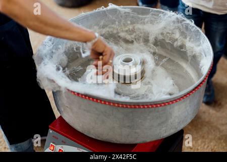 Zuckerwatte, Zuckerwatte und Märchenseide wurden bei einem gesellschaftlichen Event für Kinder gesurft. Es wird aus Zucker in der Maschine hergestellt. Stockfoto