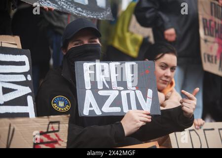 Ukrainische Militärfrau, Verteidigerin von Mariupol, posiert mit einem Schild "Freies Asov" auf einer öffentlichen Demonstration. Kiew - 21. April 2024 Stockfoto