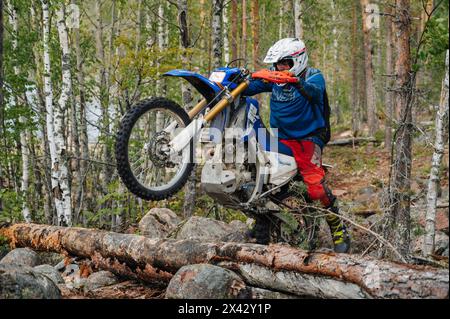 REPUBLIK KARELIEN, RUSSLAND - CA. JUNI 2022: Offroad-Turnier Ladoga Trophy 2022 in Karelien. Motorradrennfahrer auf Sport Motorrad springt über Hindernis auf der anspruchsvollen Rennstrecke Stockfoto