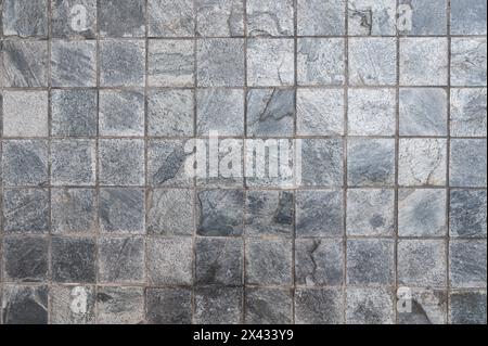 Klassische Fliesen aus Steinmauer aus kleinen quadratischen Teilen Stockfoto