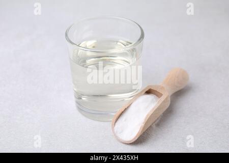 Essig in Glas, Natron und Holzlöffel auf dem Leuchttisch Stockfoto