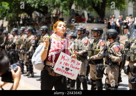 Austin, USA. April 2024. Während eines pro-palästinensischen Protestes an der University of Texas at Austin (UT Austin) in Austin, USA, am 29. April 2024, bläst eine Frau Blasen. Mehr als 100 Menschen wurden verhaftet, als am Montagnachmittag Polizei und pro-palästinensische Demonstranten auf dem Campus von UT Austin zusammenstießen, berichteten lokale Medien unter Berufung auf Beamte des Travis County. Die Beamten sagten, die Anklage könnte den Widerstand gegen Festnahme und Körperverletzung beinhalten. Quelle: Christopher Davila/Xinhua/Alamy Live News Stockfoto