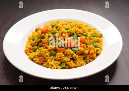Karotten und Erbsen Pilaf oder Gajar Matar Pulao. Es ist ein eintöniges Reisgericht mit Basmati-Reis und Gemüse, gewürzt mit Gewürzen, serviert mit Joghurt Stockfoto