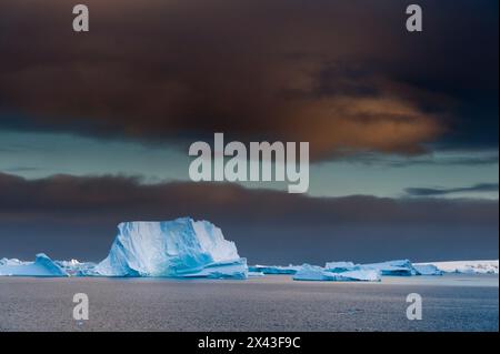 Eisberge unter Gewitterhimmel, Lemaire-Kanal, Antarktis. Stockfoto