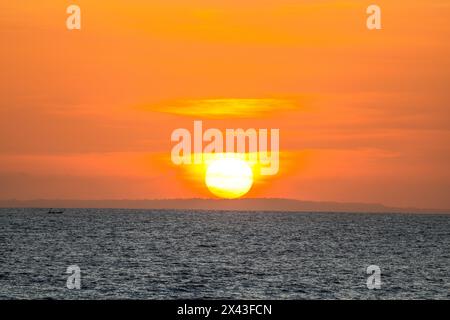 Das goldene Licht der untergehenden Sonne reflektiert ein goldenes Leuchten am Strand am Pererenan Beach, während die Wellen auf Bali, Indonesien, hereinbrechen Stockfoto