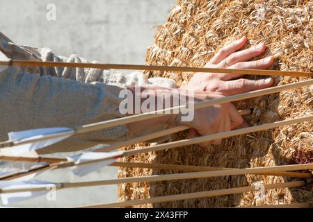 Italien. Lombardei, Nachstellung mittelalterlich, Archer nimmt den Pfeil vom Strohziel Stockfoto