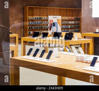 Paris, Frankreich - 23. Dezember 2023: Elegante Gadgets in einem modernen Elektronikgeschäft mit Tablets und Telefonzubehör - leerer Apple Computer-Laden mit großem Stand im Hintergrund mit magasafen Zubehör Stockfoto