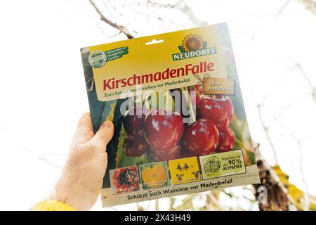 Frankfurt, Deutschland - 9. März 2024: Hand mit Neudorff Kirschmaschenfalle vor verschwommenem Hintergrund, umweltfreundliches Produkt - bereit zum Anbringen am Kirschbaum Stockfoto