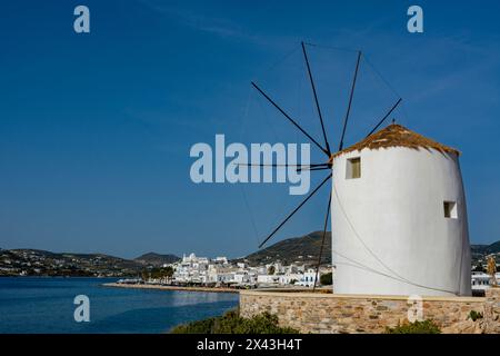 Eine malerische Aussicht auf die Uferpromenade von Parikia und eine traditionelle Windmühle. Parikia, Insel Paros, Kykladen, Griechenland. Stockfoto