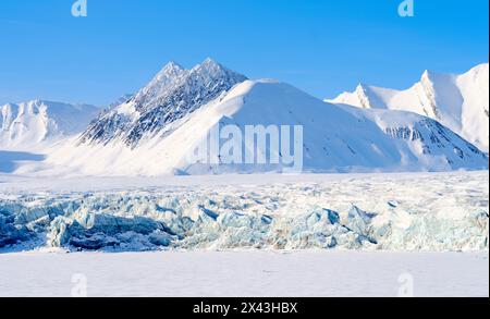 Gletscherfront von Fridtjovbreen und der gefrorene Fjord Van Mijenfjord. Landschaft im Van-Mijenfjorden-Nationalpark (ehemaliger Nordenskiold-Nationalpark) Stockfoto