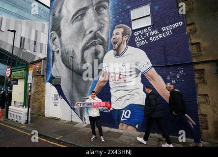 Ein Fan posiert für ein Foto vor einem Wandbild des ehemaligen Tottenham Hotspur Spielers Harry Kane, vor dem Premier League Spiel im Tottenham Hotspur Stadium in London. Bilddatum: Sonntag, 28. April 2024. Stockfoto