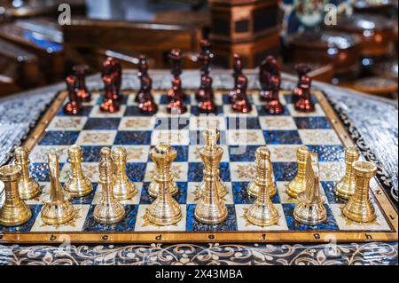 Souvenir-Schach aus Metall auf einem Holzbrett in einem orientalischen Souvenirladen in Usbekistan Stockfoto