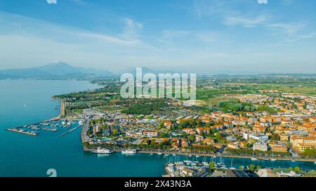 Mit Blick auf die malerische Stadt Peschiera del Garda, eingebettet in das ruhige Wasser des Gardasees, mit Blick auf die umliegende Landschaft. Stockfoto