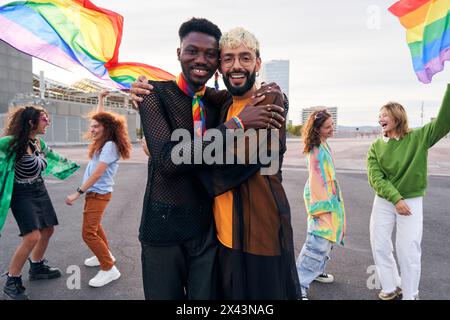 Zwei Männer auf der Pride Parade feiern den LGBTQIA-Monat, umarmen und schauten fröhlich in die Kamera. Stockfoto