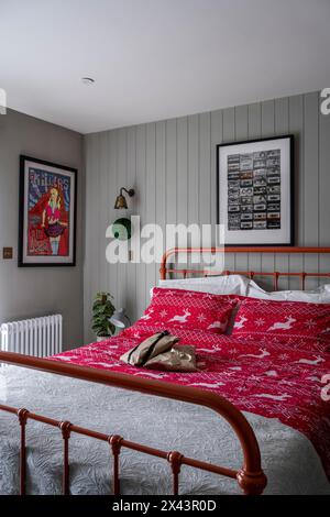 Rote Weihnachtsdecke auf Metall gerahmtes Bett in East Sussex Haus, Südostengland, Großbritannien Stockfoto