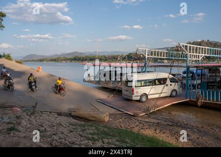 Eine laotische Fähre transportiert Motorräder, Motorroller, verschiedene Fahrzeuge und Passagiere auf dem Fluss Mekong in Luang Prabang Laos Asien Stockfoto