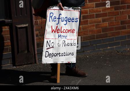 Loughborough, Leicestershire, Großbritannien. 30. April 2024. Ein Demonstrant, der gegen die geplante Deportation von Migranten und Flüchtlingen nach Ruanda demonstriert, steht vor einem Meldezentrum für Einwanderungsbehörden. Credit Darren Staples/Alamy Live News. Stockfoto