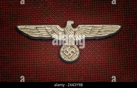 Deutscher nazi-Hutabzeichen aus dem Zweiten Weltkrieg auf dunkelrotem Hintergrund Stockfoto