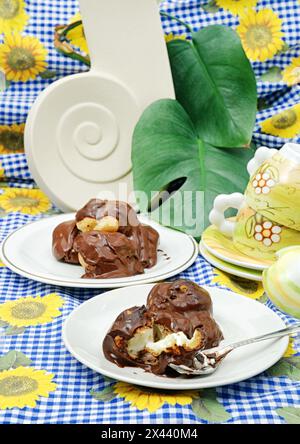 Mit Creme gefüllte Schoko-Profiterolen. Stockfoto